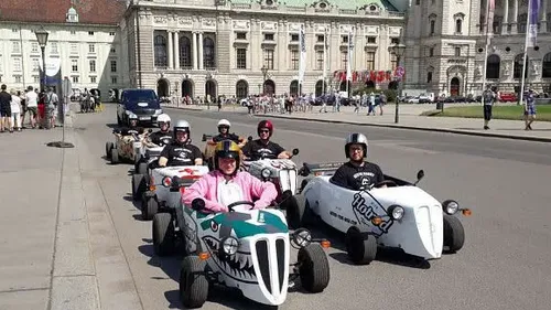 Group of people driving mini cars in city.