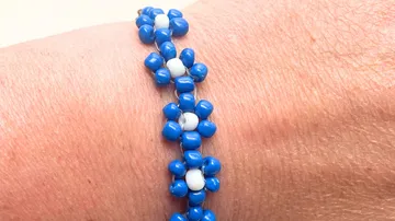 Blau-weißes Perlenarmband am Handgelenk.