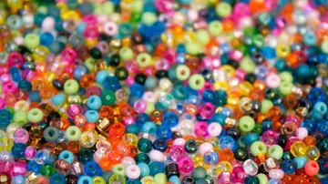 Bunte Perlen zufällig auf Oberfläche verstreut.