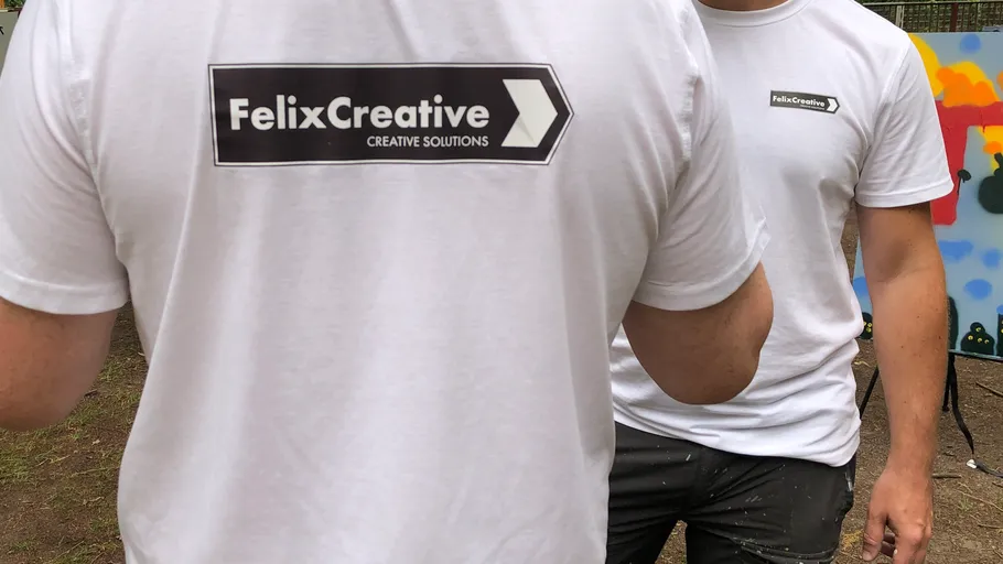 Two people wearing FelixCreative shirts outdoors.