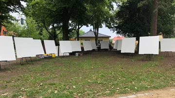 Empty canvases on easels in a park setting.