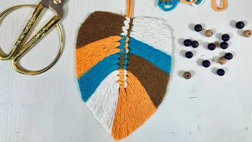 Colorful leaf-shaped string art with scissors.