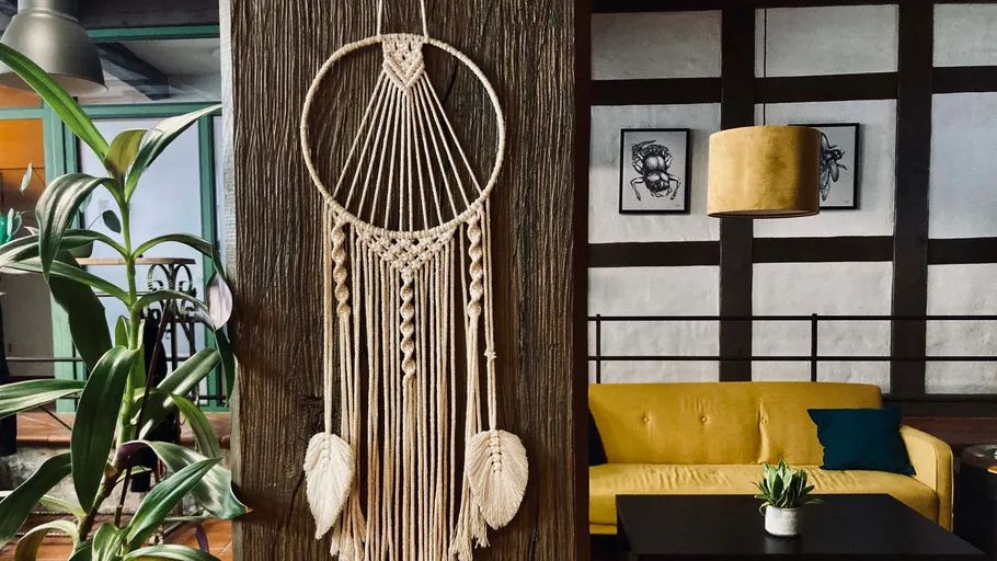 Macrame on wall beside modern living room setting.