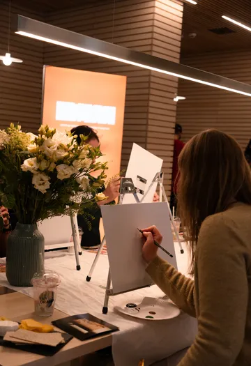 Person drawing on canvas at indoor workshop.