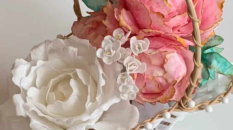 Decorative flowers arranged in a woven basket.