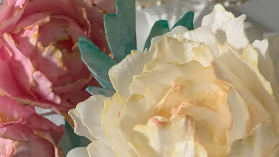 Close-up of colorful artificial flowers in sunlight.