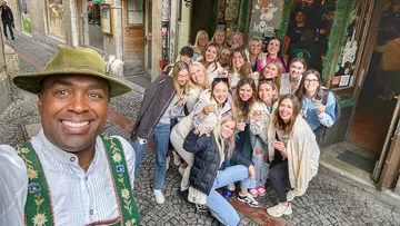 Group posing happily on cobblestone street.