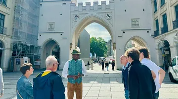Guide talking to tourists in city square.