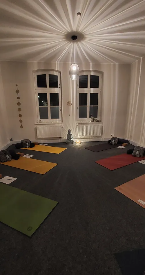 Yoga mats arranged in a dimly lit room.