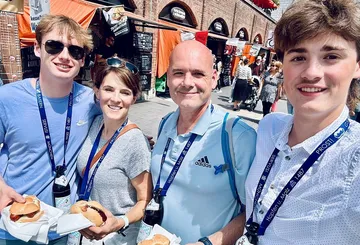 Gruppe von vier Personen lächelnd, Essen haltend, Markt.