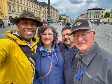 Four people smiling in a city square.