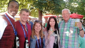 Group of five people enjoying outdoor festival.