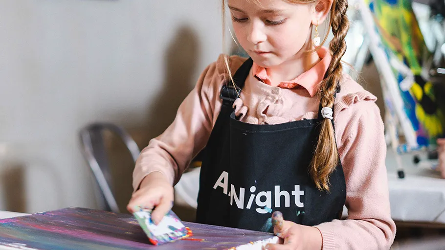 Girl painting with spatula in art class.