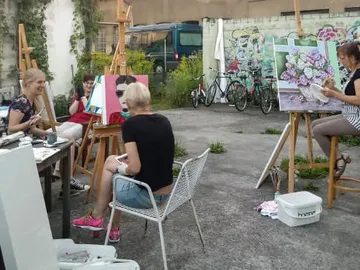 Grouped outdoor painting, artists working on canvases.