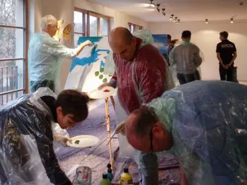 People paint together in a bright room.