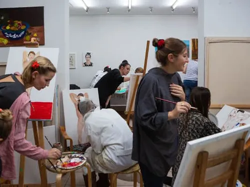 Artists paint various paintings in a studio.