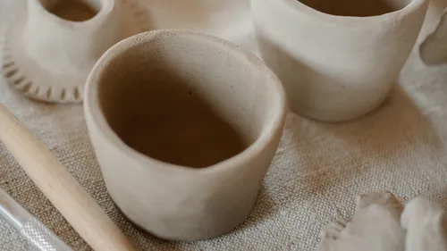 Clay pots on a woven fabric surface.