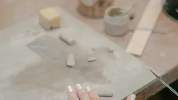Hand glättet Tonteile auf einem Tisch.