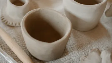 Unfinished clay pots on a textured surface.