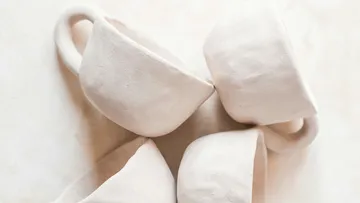 White ceramic cups stacked on table.