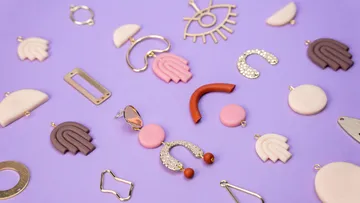 Colorful earrings scattered on purple background.