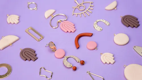 Colorful earrings scattered on purple background.