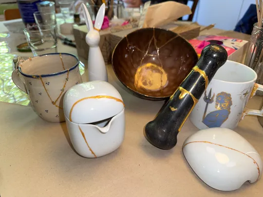 Reparierte Keramiken mit Kintsugi-Technik auf Tisch.