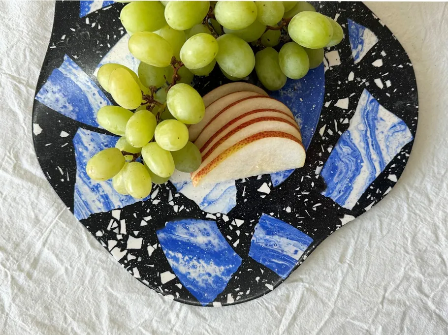 Grapes and pear slices on patterned plate.