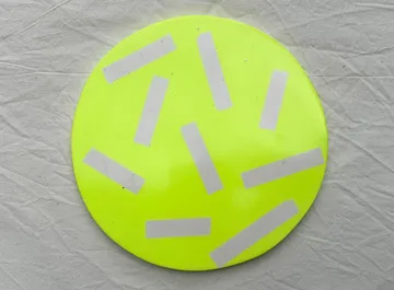 Yellow disc with reflective strips on cloth.