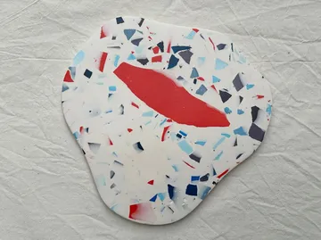 Colorful terrazzo coaster on white fabric.