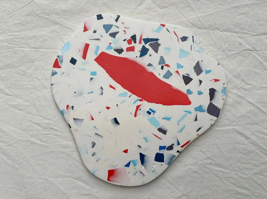 Colorful terrazzo coaster on white fabric.