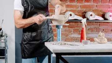 Person shaping clay in a pottery studio.