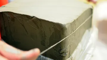 Tonblock wird mit dünnem Draht geschnitten.