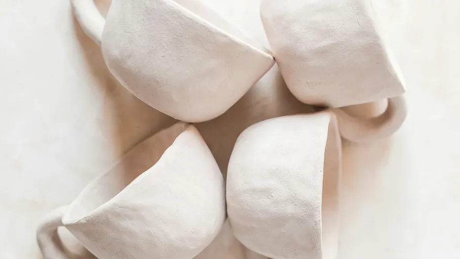 Four white ceramic mugs, arranged together closely.