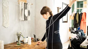 Woman measuring string in craft studio.