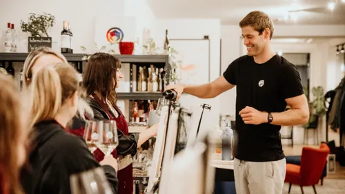 Man pouring wine for group in a store.