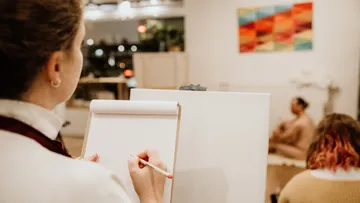Person drawing a model in an art studio.