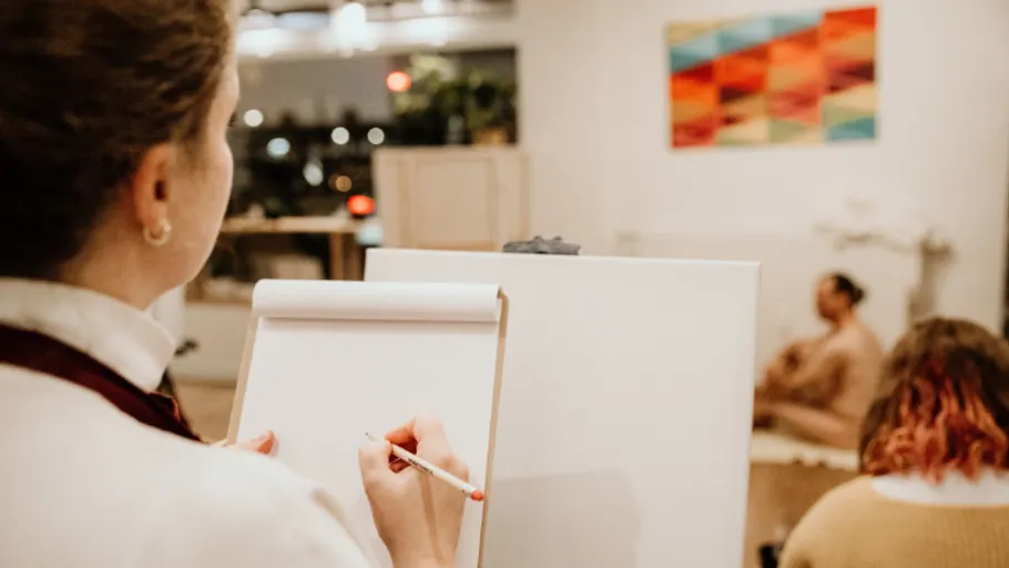 Person drawing a model in an art studio.