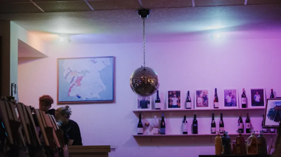 Diskokugel hängt in Weinbar-Interieur.