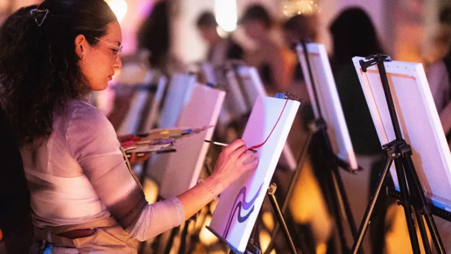 Frau malt bei einem Kunstkurs-Event.