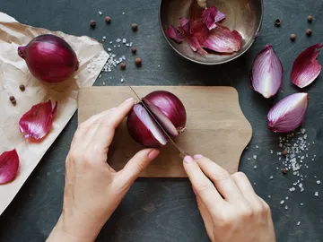 Red onion is cut on a cutting board.