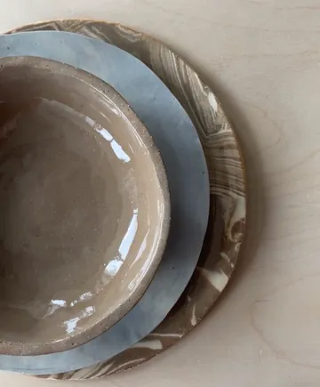 Three stacked ceramic dishes on wood surface.