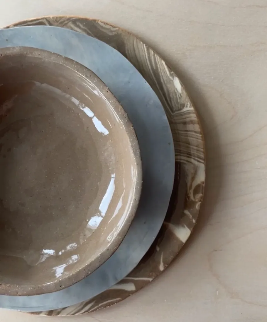 Three stacked ceramic dishes on wood surface.