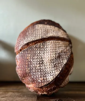 Round sourdough bread on wooden table.