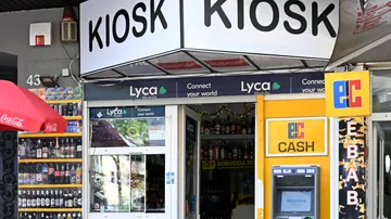 Kiosk-Eingang mit Geldautomat und Produkten ausgestellt.