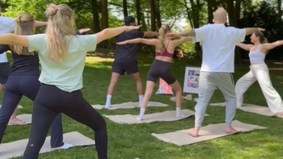 People practicing yoga in a park.