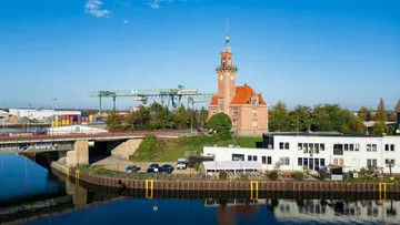 Historisches Turmgebäude an einem Flusshafen.