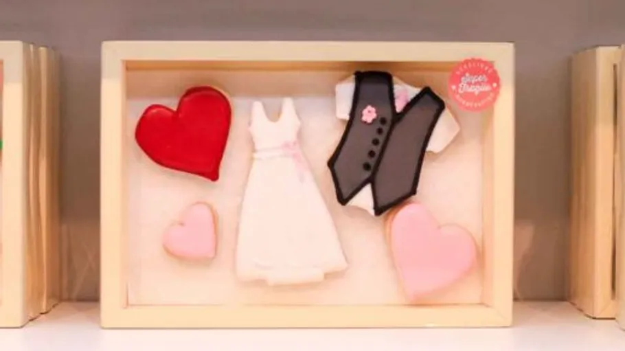 Hochzeitsthematische Kekse in einer Schachtel.