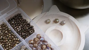 Assorted beads organized in a plastic container.
