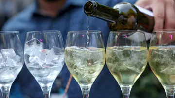 White wine poured into glasses with ice.